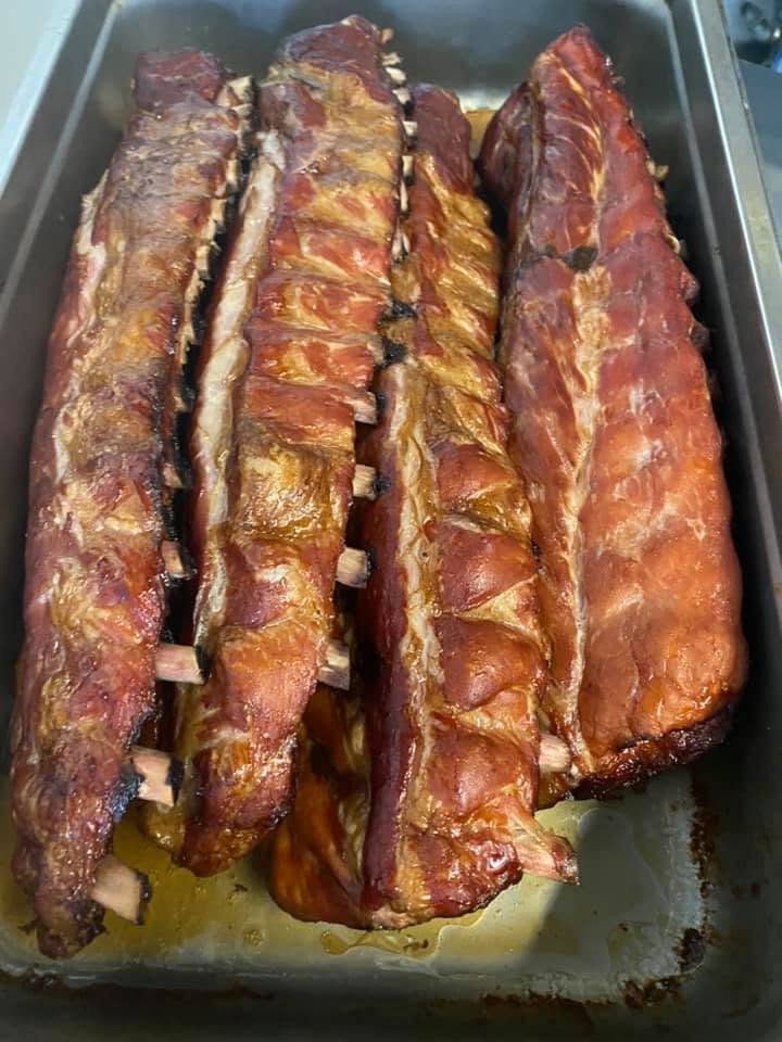 Smoked rib racks resting in a pan