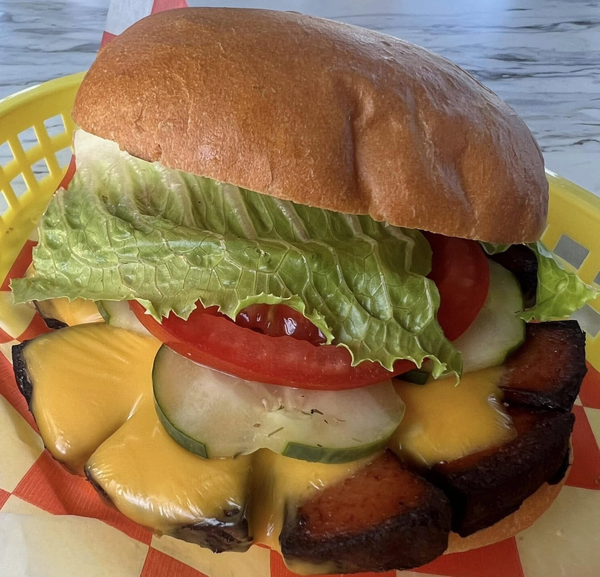 A stacked V9 burger with lettuce, tomato and pickles