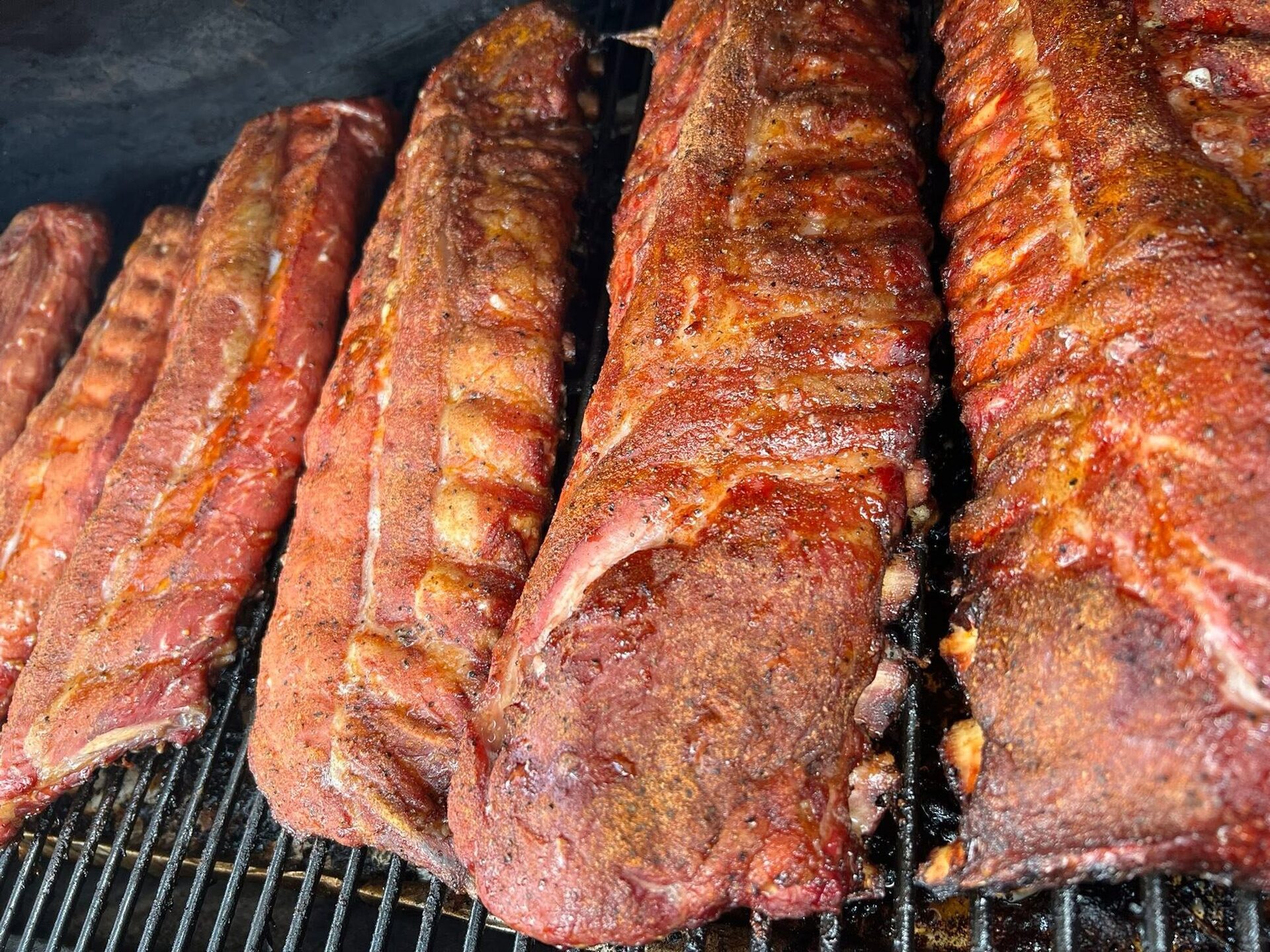 Racks of baby back ribs on the smoker grate