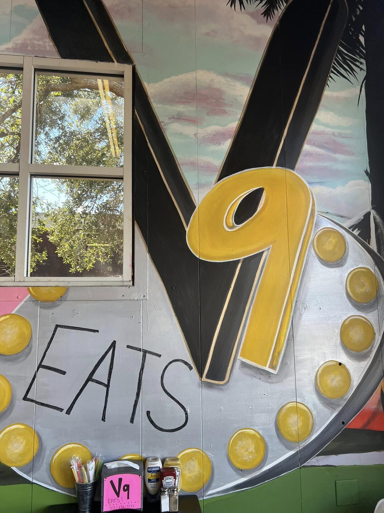 The marquee-bulb V9 EATS sign on the dining-room wall