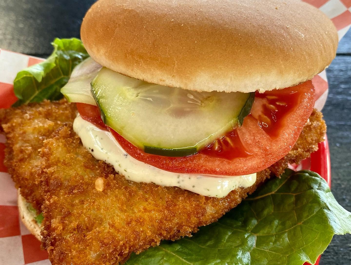 Hand-breaded pork schnitzel sandwich with tomato and lettuce