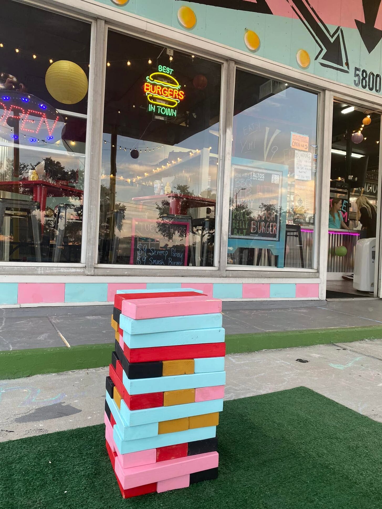 Giant painted Jenga tower on the patio turf in front of V9's garage-bay windows