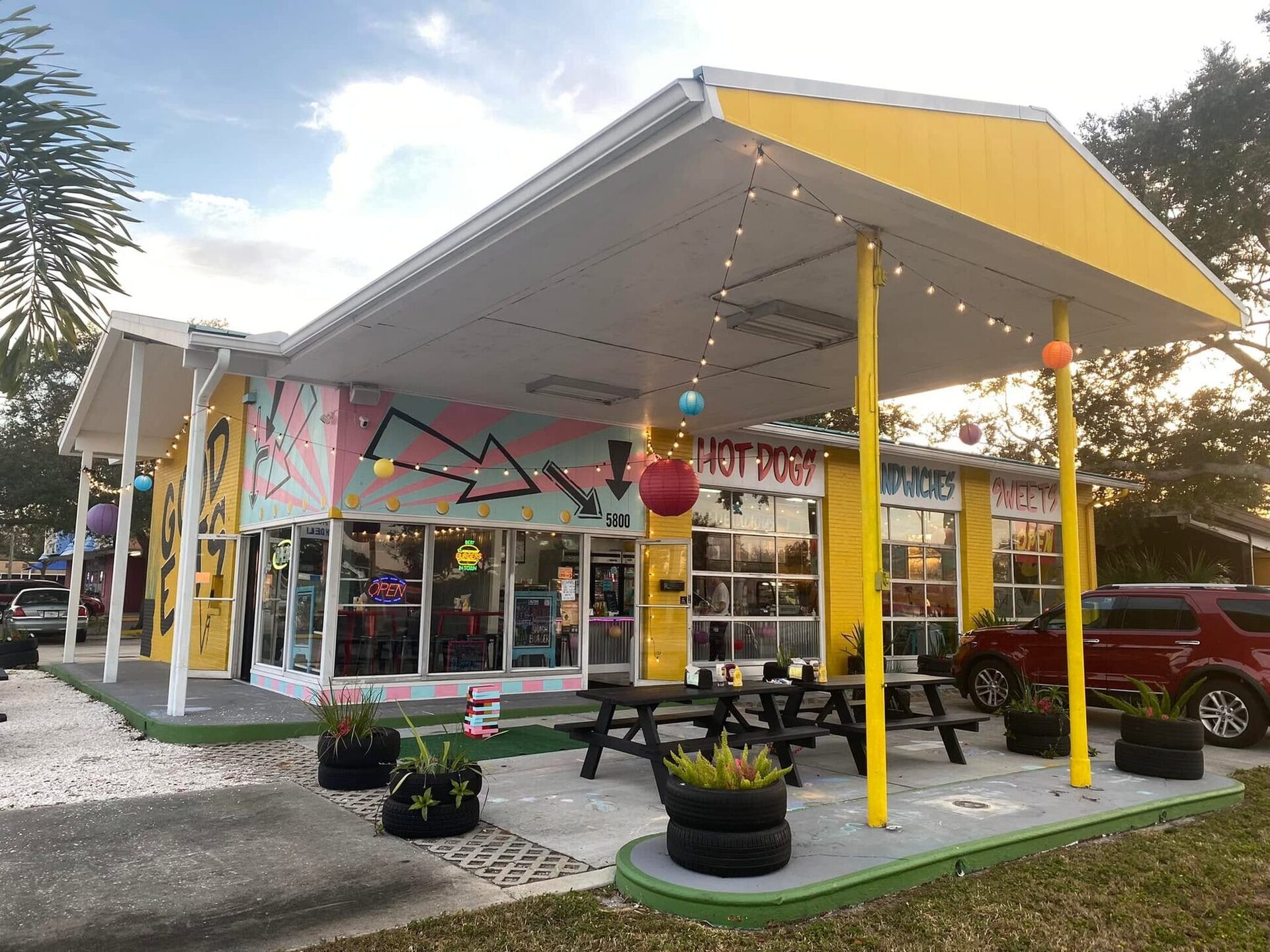 V9 EATS at 5800 9th Ave N: the yellow canopy, tire planters and picnic tables