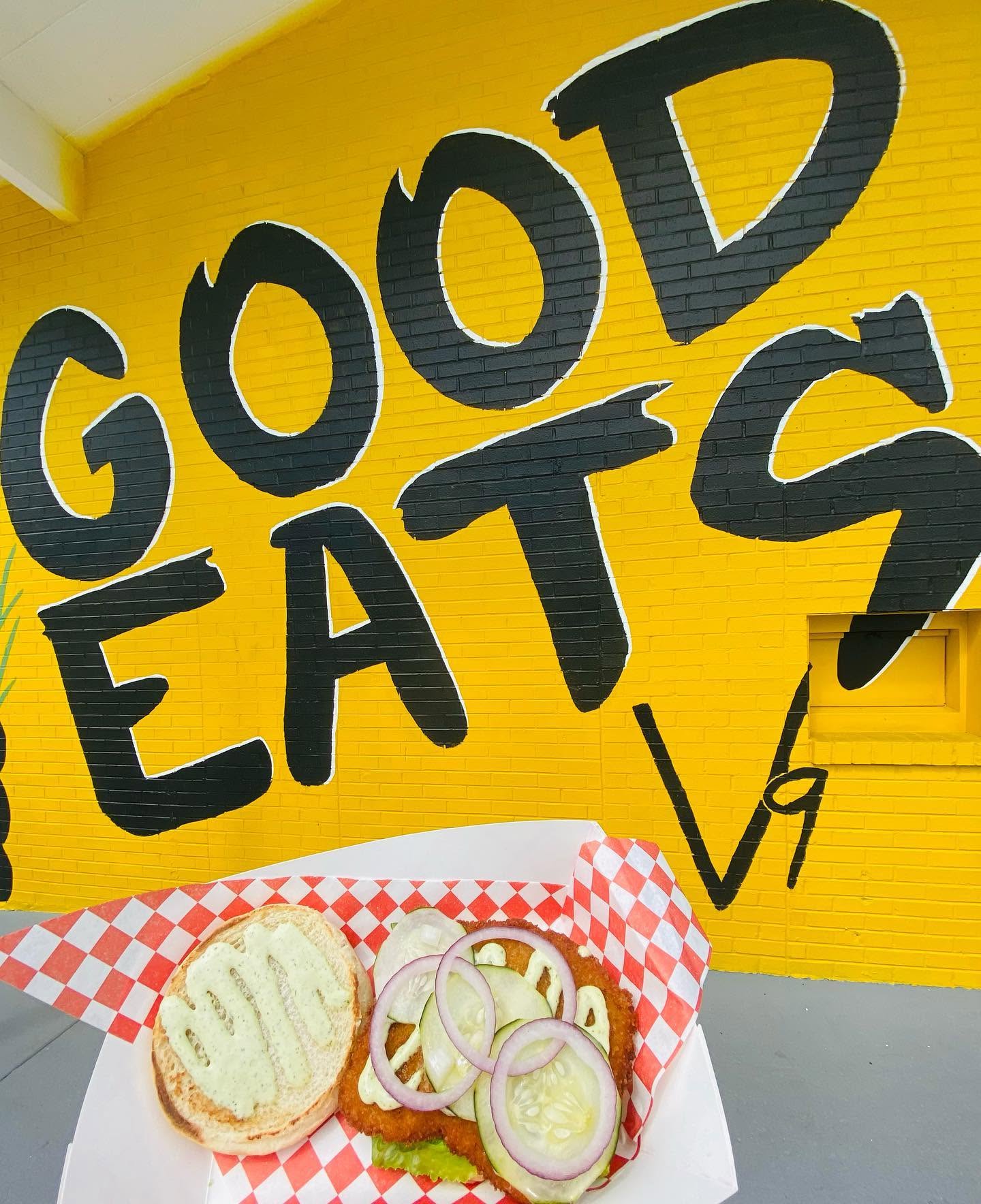 A sandwich basket in front of the hand-painted GOOD EATS mural